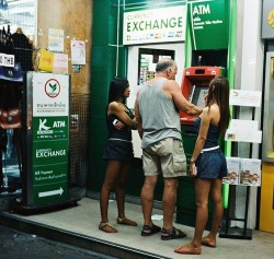 Man withdrawing cash from ATM in Thailand.