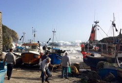 fishermen pulling their boats up to safety at Cadgwith