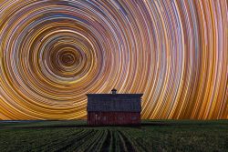 Star trails over a farmhouse