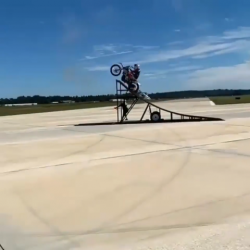 Motorbike jumps biplane