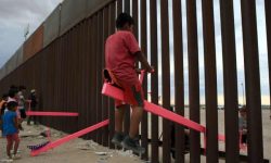 American and Mexican families enjoying the Teeter Totter Wall, which crosses the Mexican border  ...