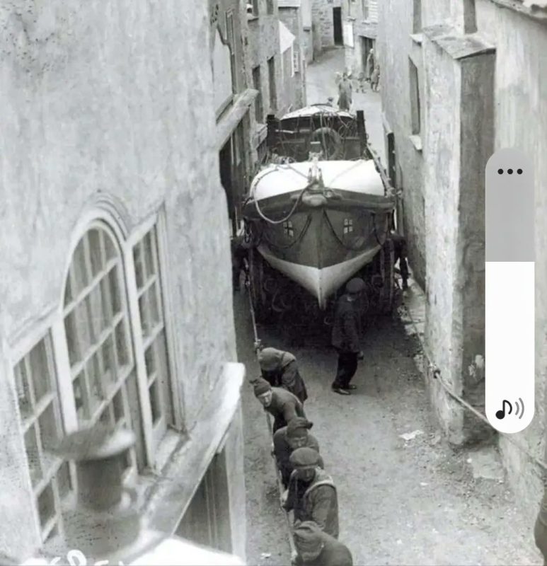 Sailors pull the lifeboat through the narrow streets of Port Isaac in Cornwall from the construc ...