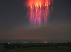 A beautiful, and unusually large, red sprite jellyfish over Oklahoma fields. The color transitio ...