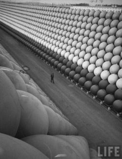 A security guard walking down US Highway 101 where there are towering stacks of hollow iron floa ...